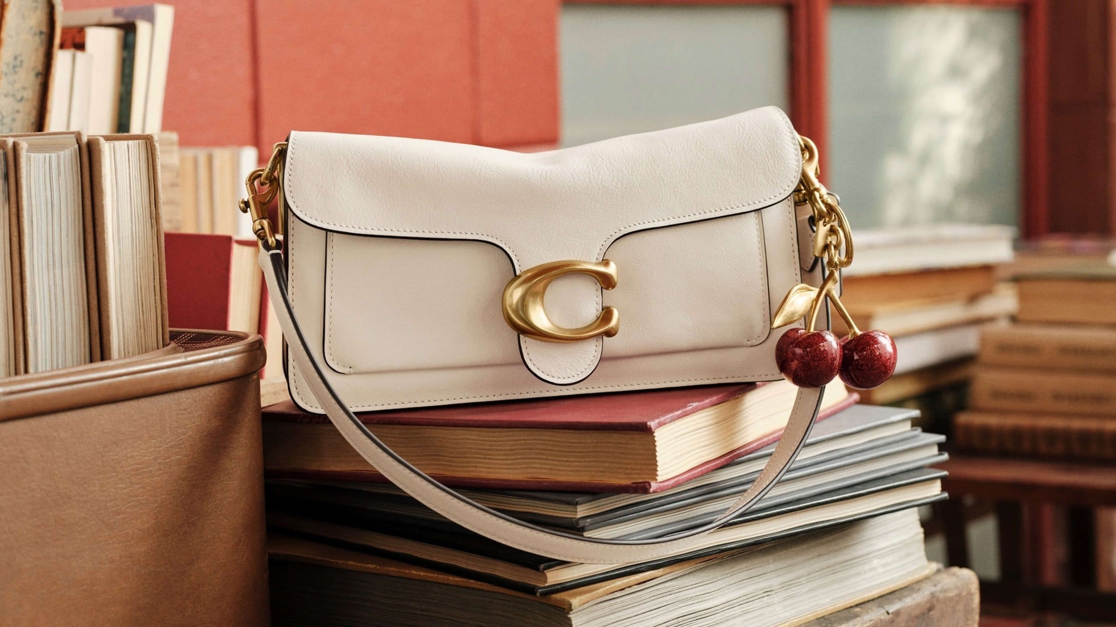 Coach Tabby 26 in chalk, natural grain leather, with the cherry bag charm. Image courtesy of Coach.