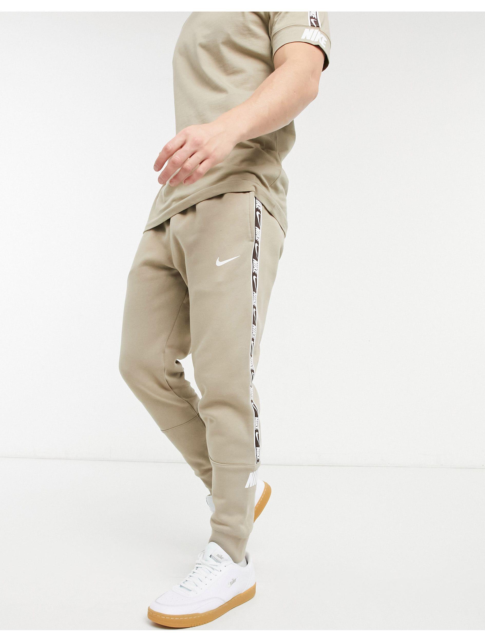 nike repeat pack logo taping cuffed joggers in khaki