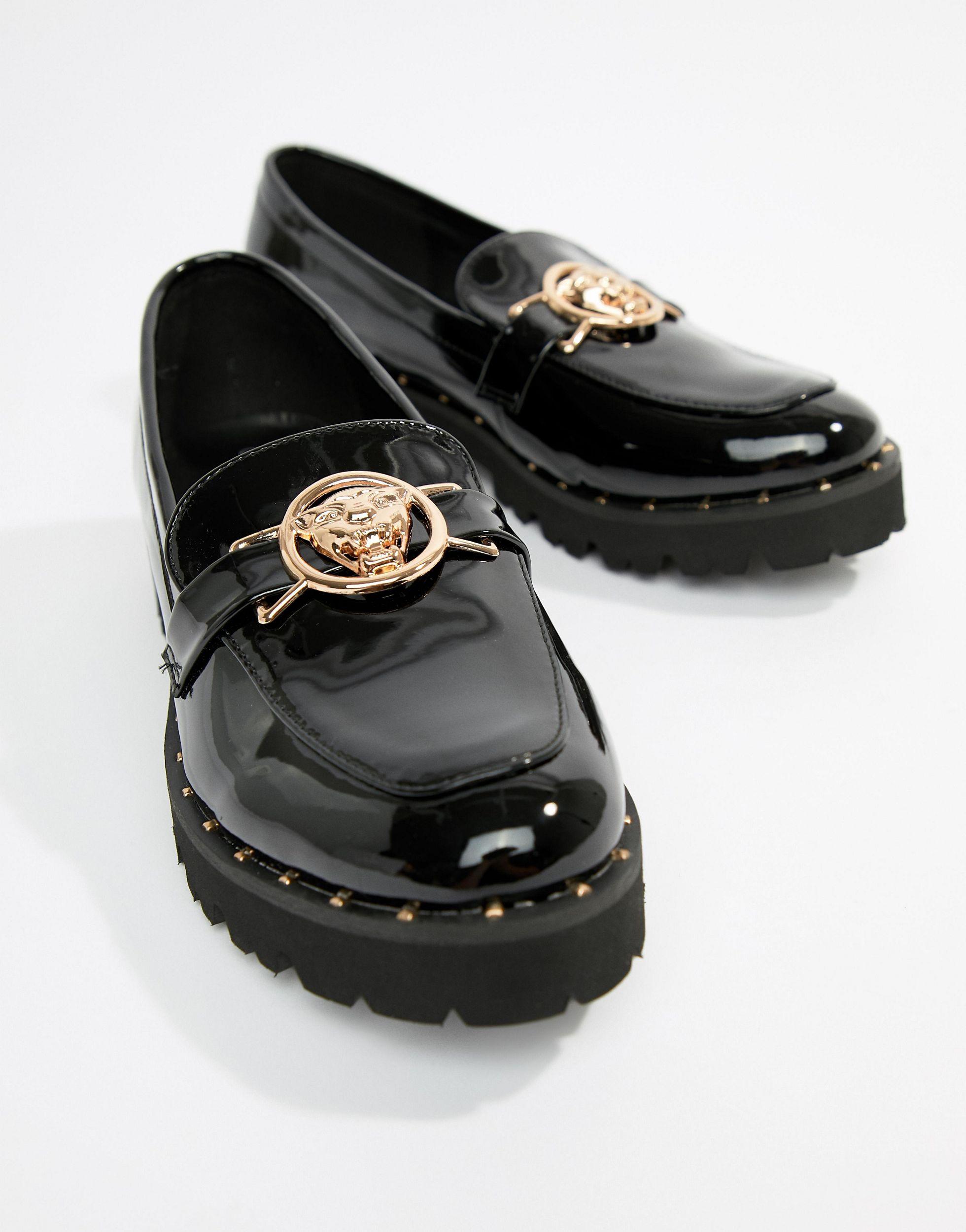 glamorous black chunky flat shoes with gold lion trim