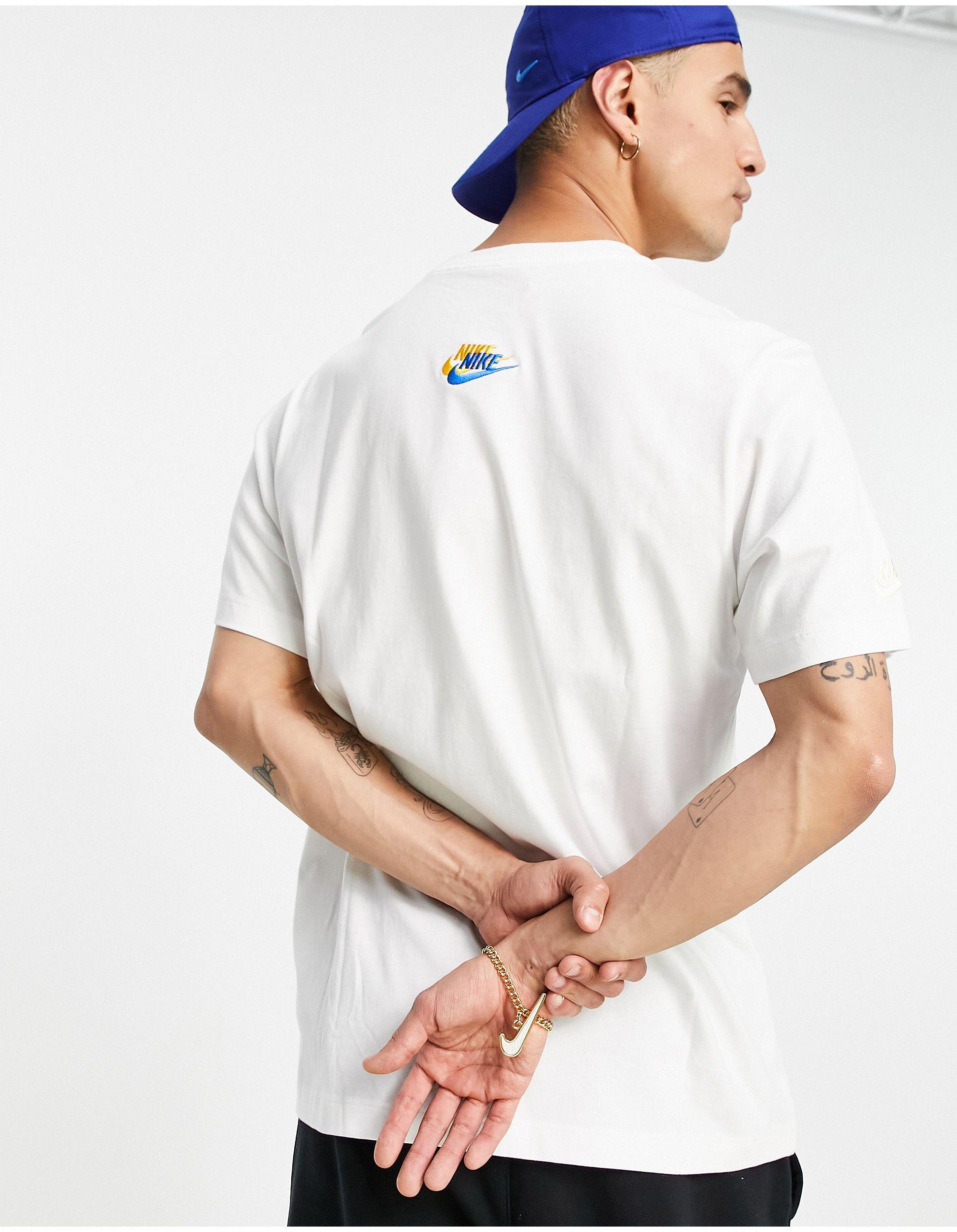 White nike shirt clearance with blue logo