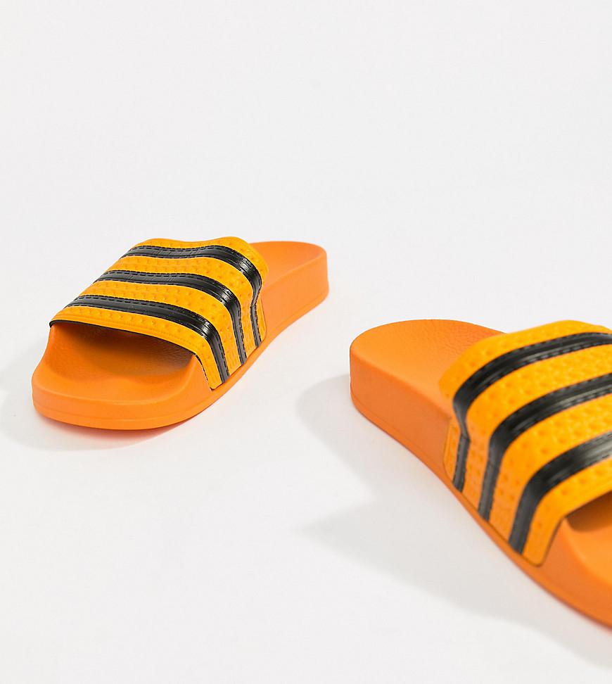 orange and black adidas slides