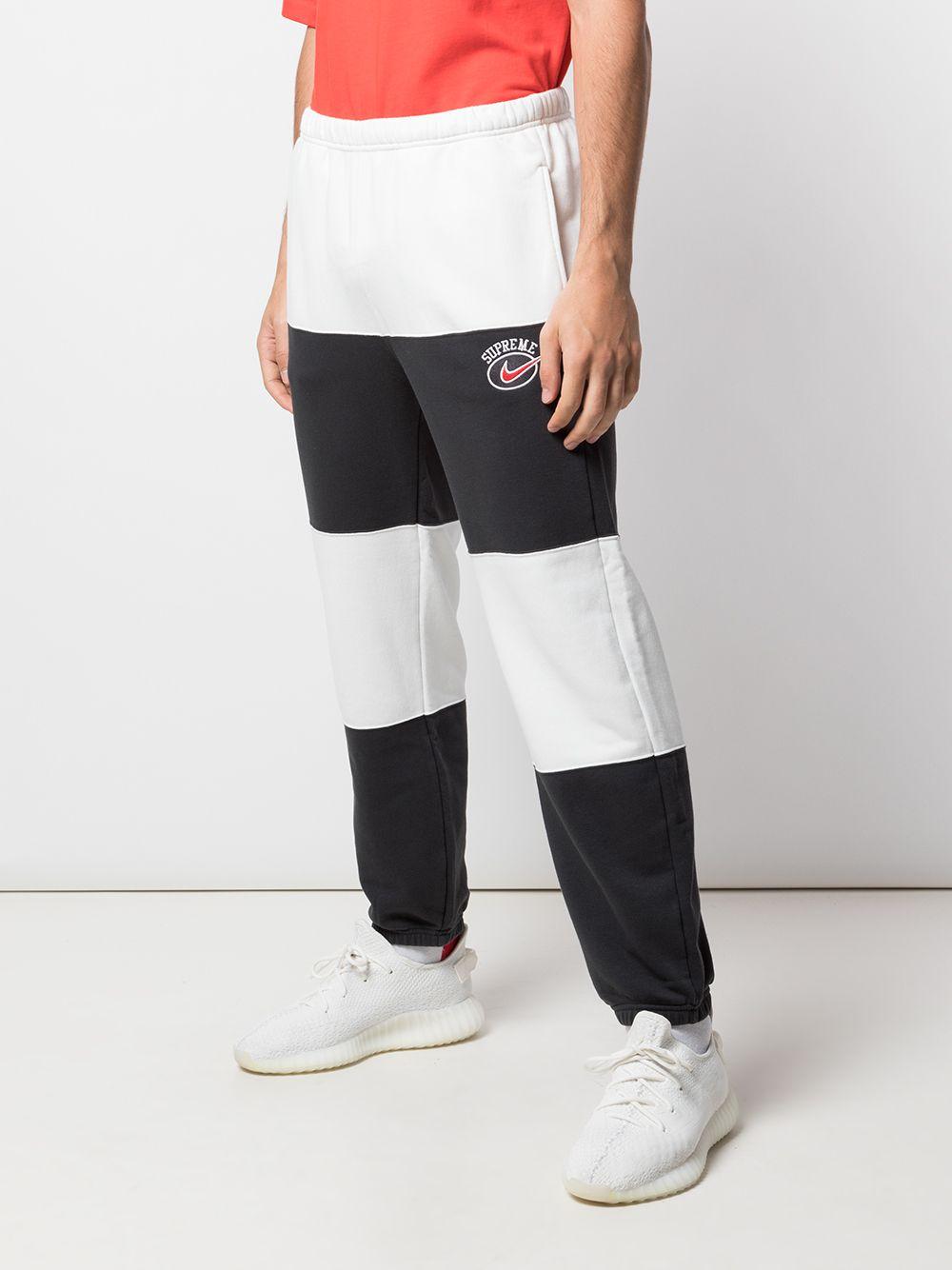 nike black track pants with white stripe