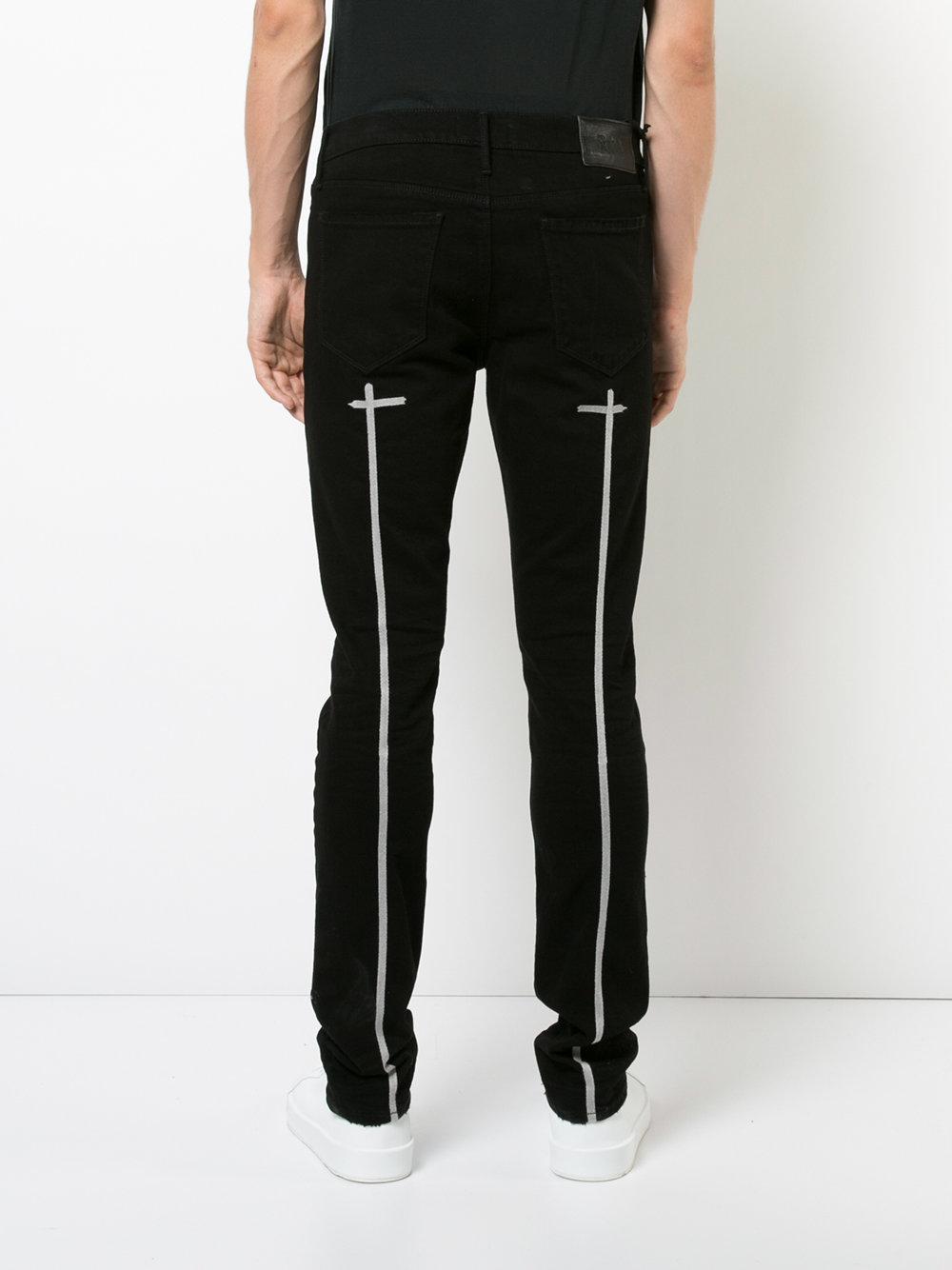 black jeans with one rip in the knee