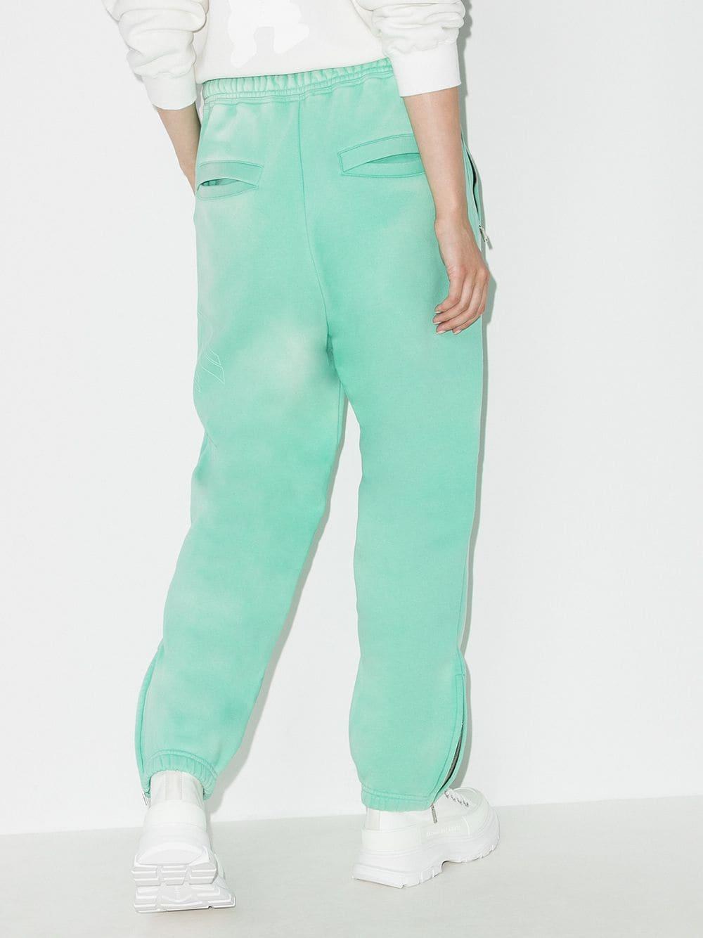 green track pants with red stripe