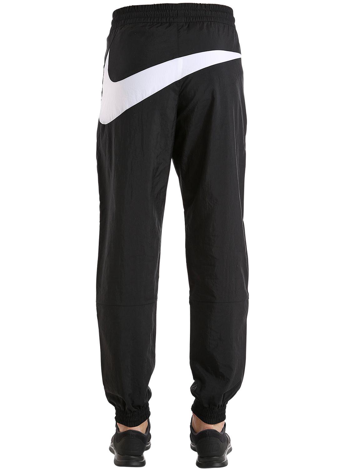 nike all over swoosh pants