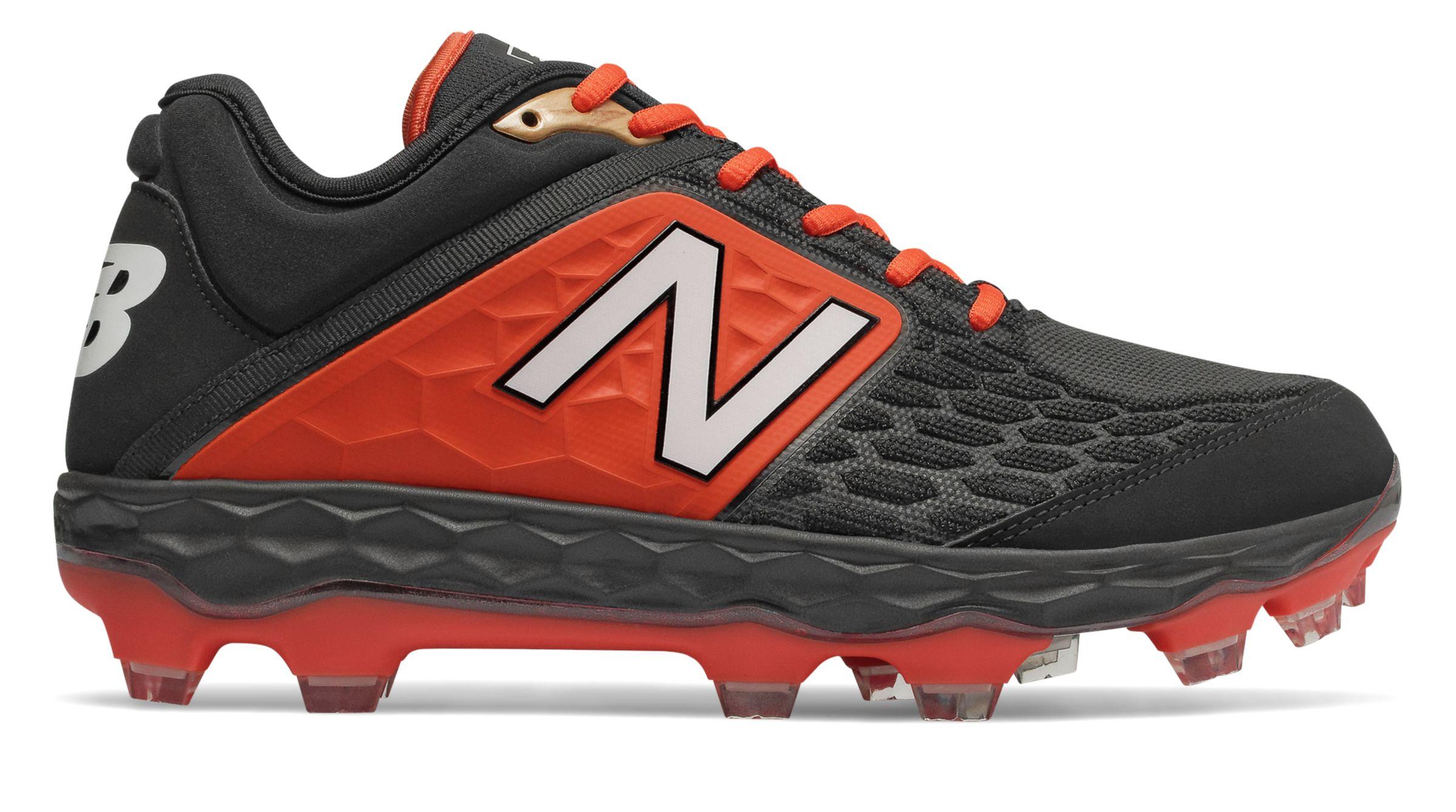 black and orange new balance turf shoes