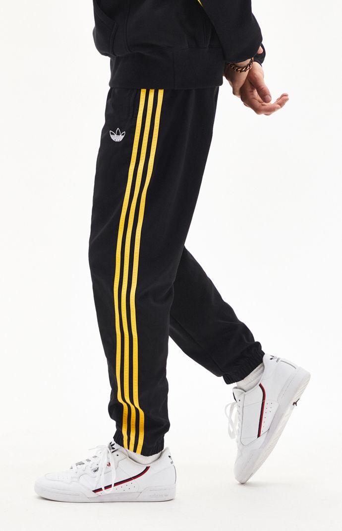 black and yellow adidas track pants