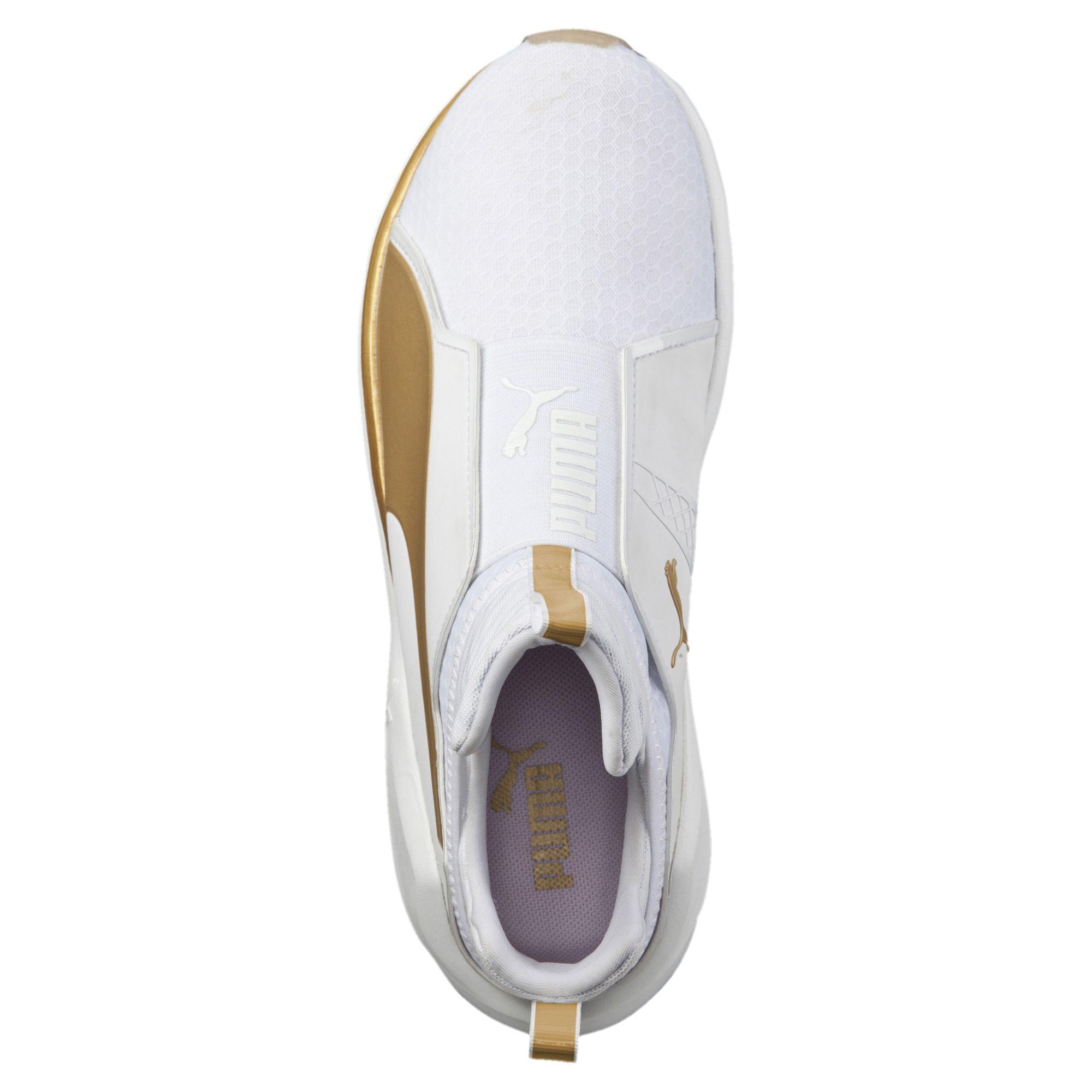 gold and white pumas with strap