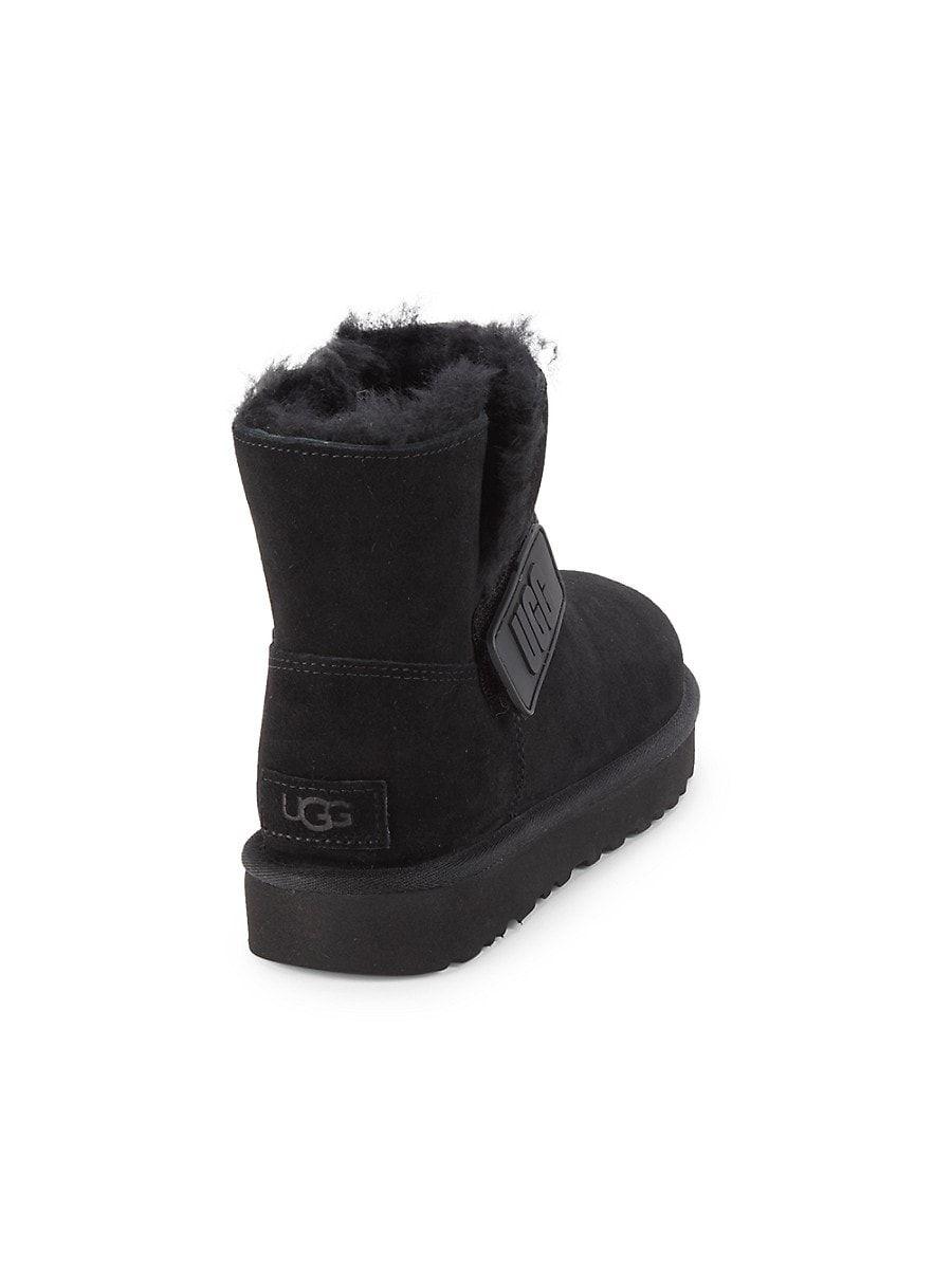 UGG Mini Bailey Logo Strap Shearling Lined Ankle Boots in Black | Lyst