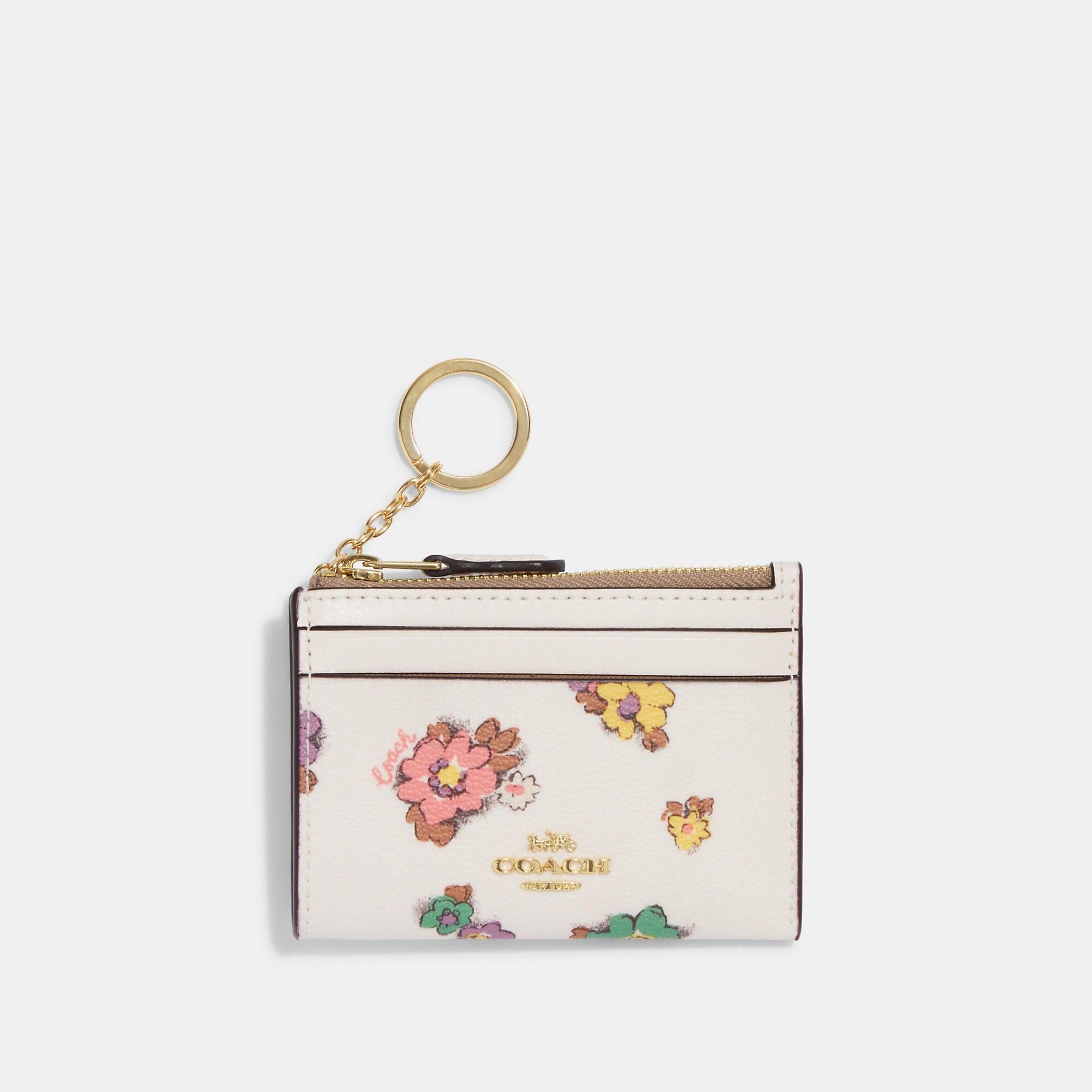 https://cdna.lystit.com/photos/shoppremiumoutlets/986b3938/coach-outlet-goldchalk-multi-Mini-Skinny-Id-Case-With-Spaced-Floral-Field-Print.jpeg