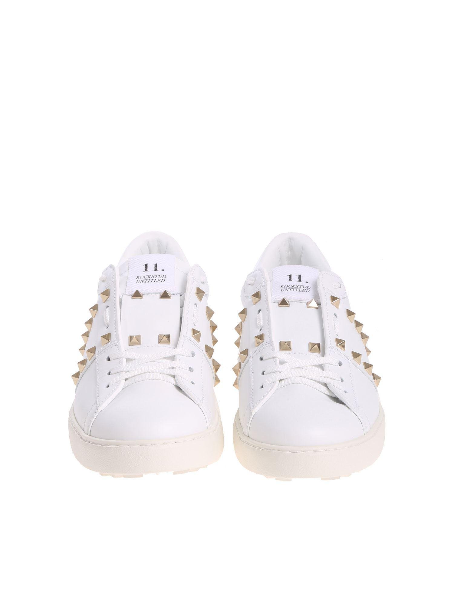 white sneakers with gold studs