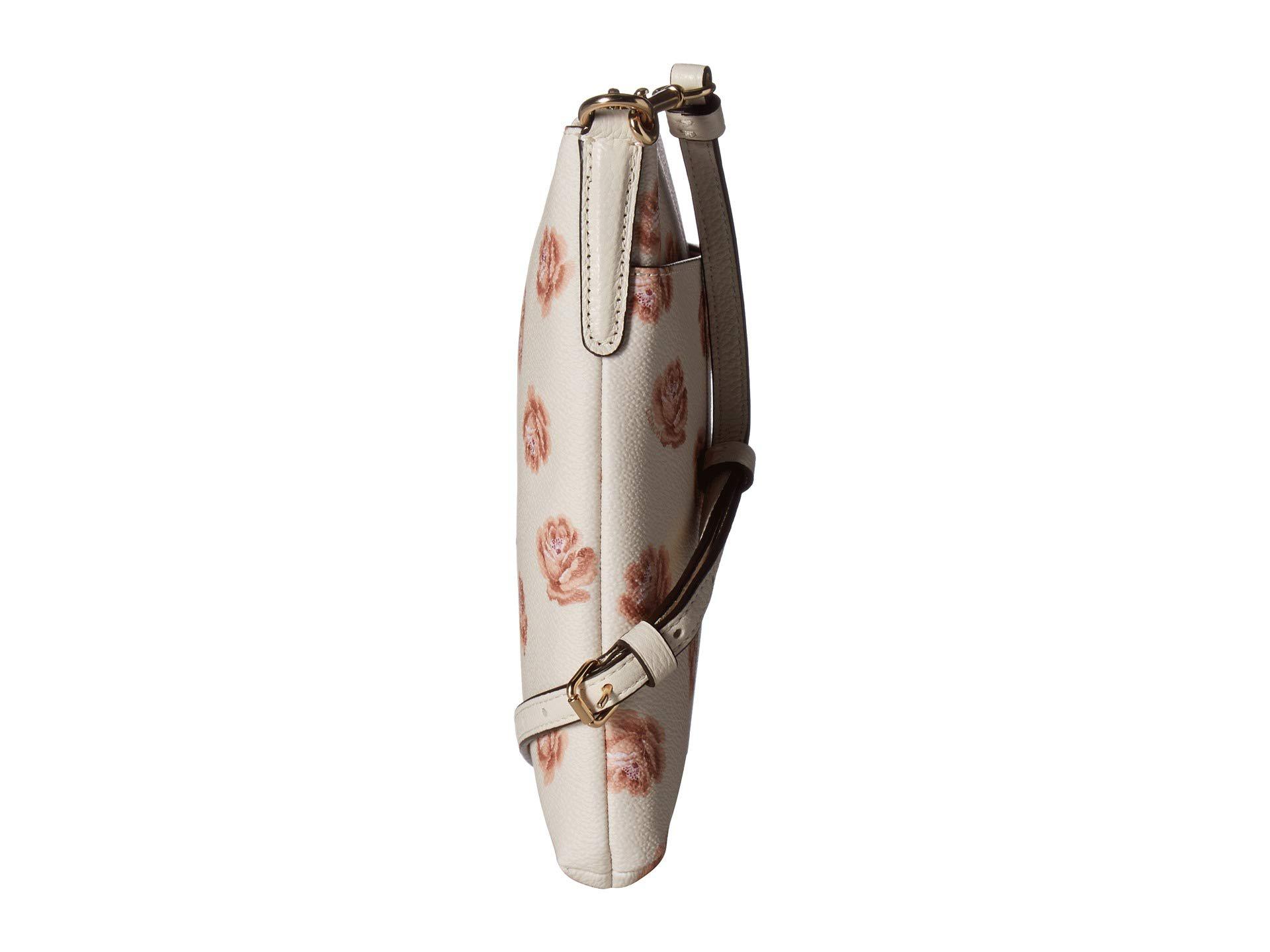 Woman holding brown and pink floral leather crossbody bag photo